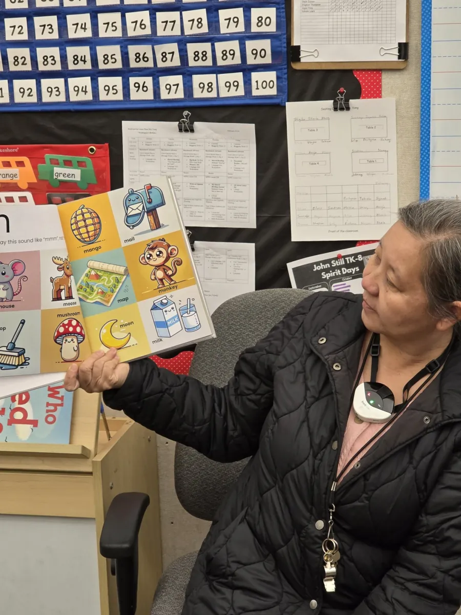 Educator looking at the illustrated m sound page of the Alphabet Sounds book